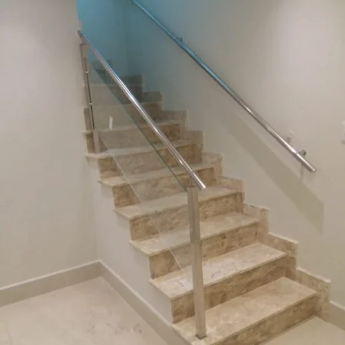 Guarda corpo de vidro e corrimão de inox instalados em escada residencial